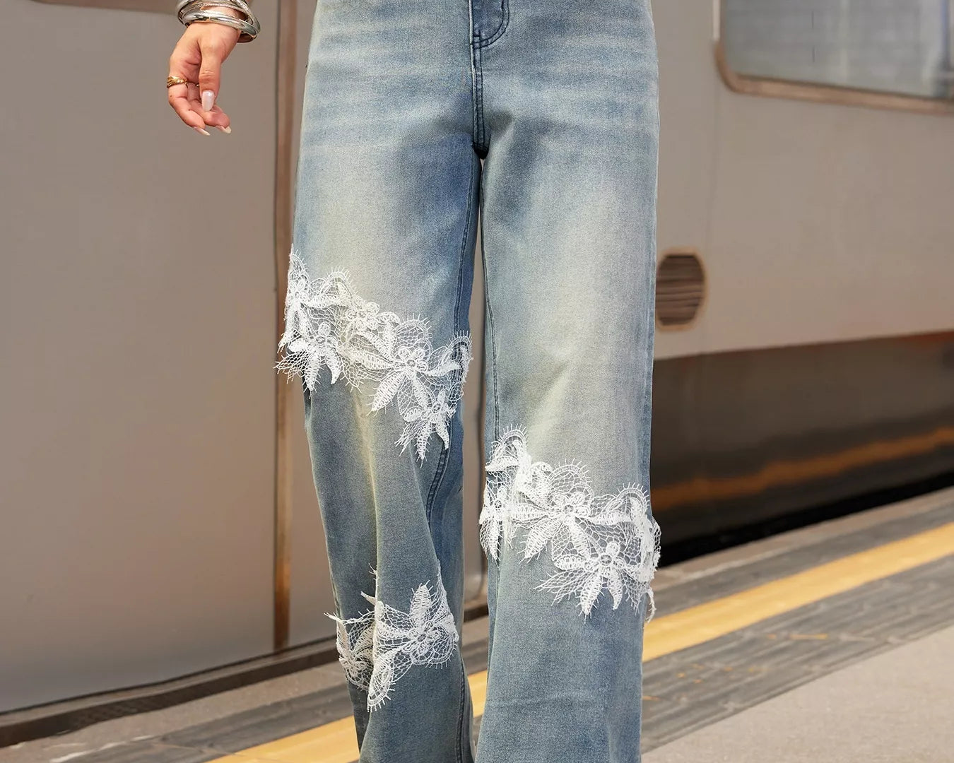 NEWYORKLISTED STYLE COLLECTION: Person wearing light blue jeans with lace details at a train station.