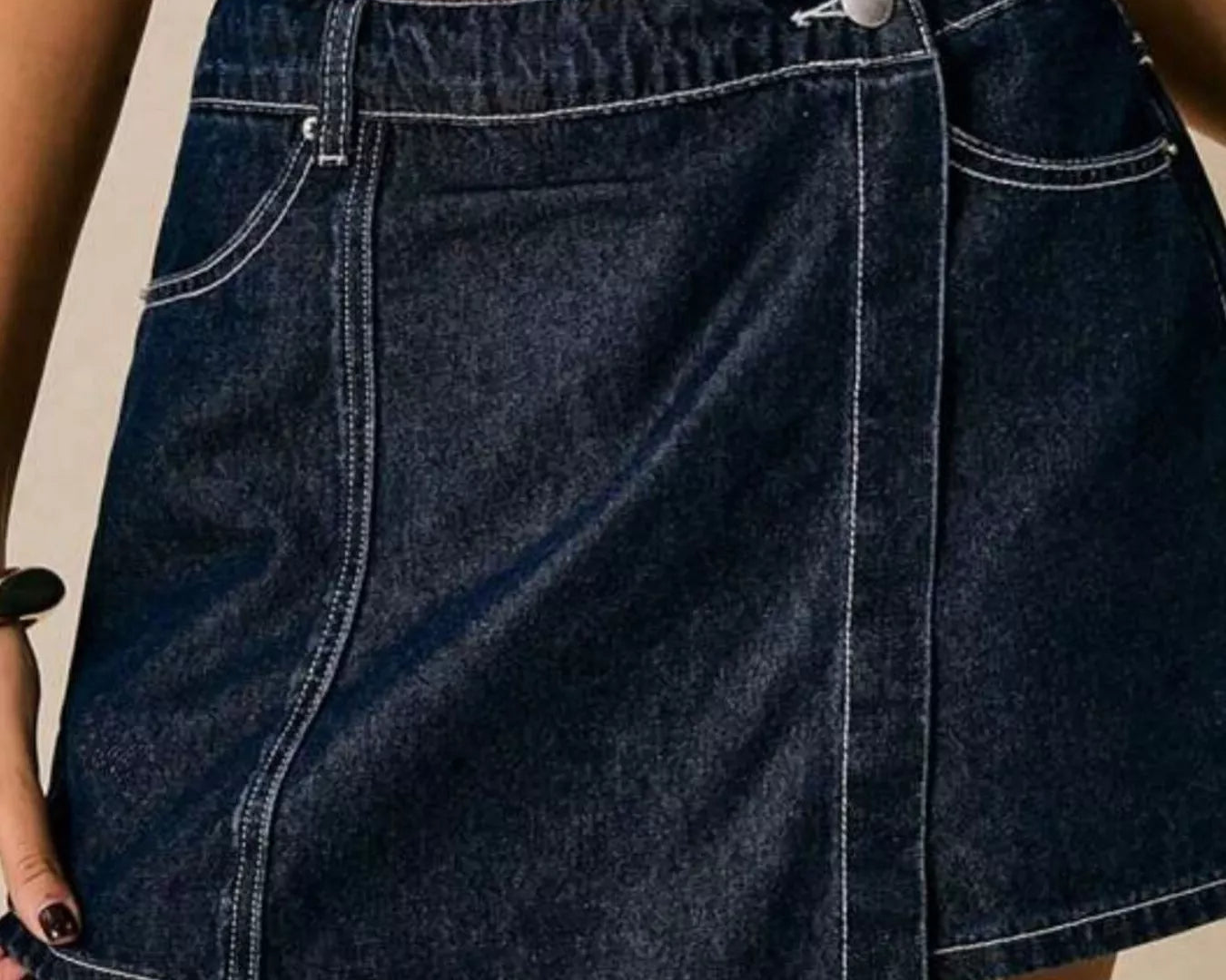 NEWYORKLISTED STYLE COLLECTION: Person wearing a blue denim skirt on a neutral background