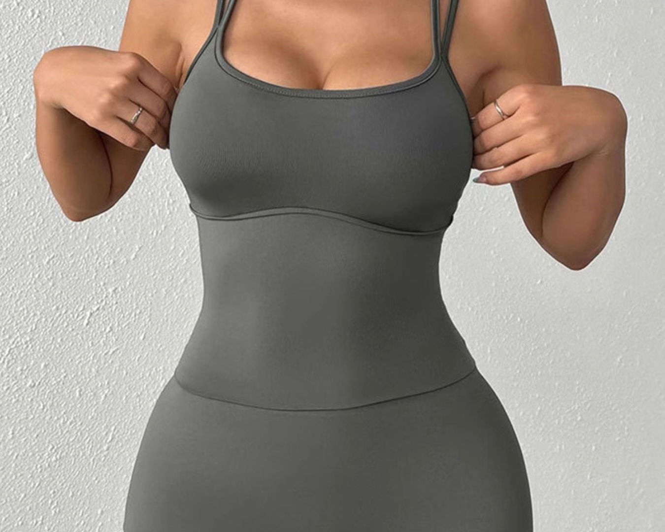 NEWYORKLISTED ACTIVEWEAR COLLECTION: Woman wearing a gray athletic outfit against a white background