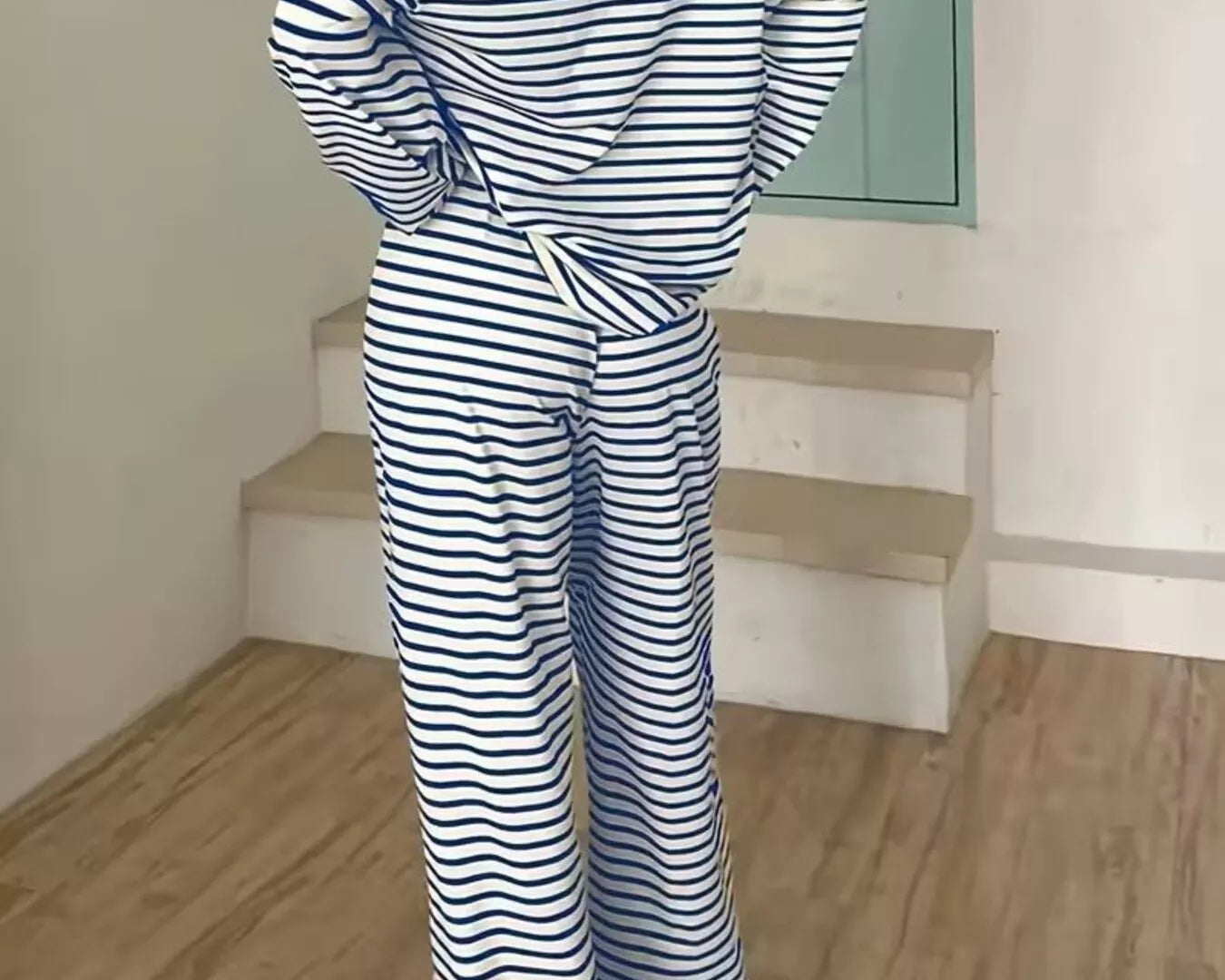 NEWYORKLISTED Comfort Collection: Person wearing a blue and white striped outfit standing on a wooden floor.