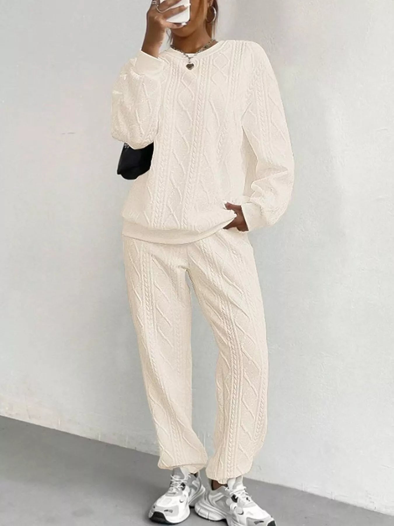 NEWYORKLISTED COMFORT COLLECTION: Person wearing a beige tracksuit against a white background