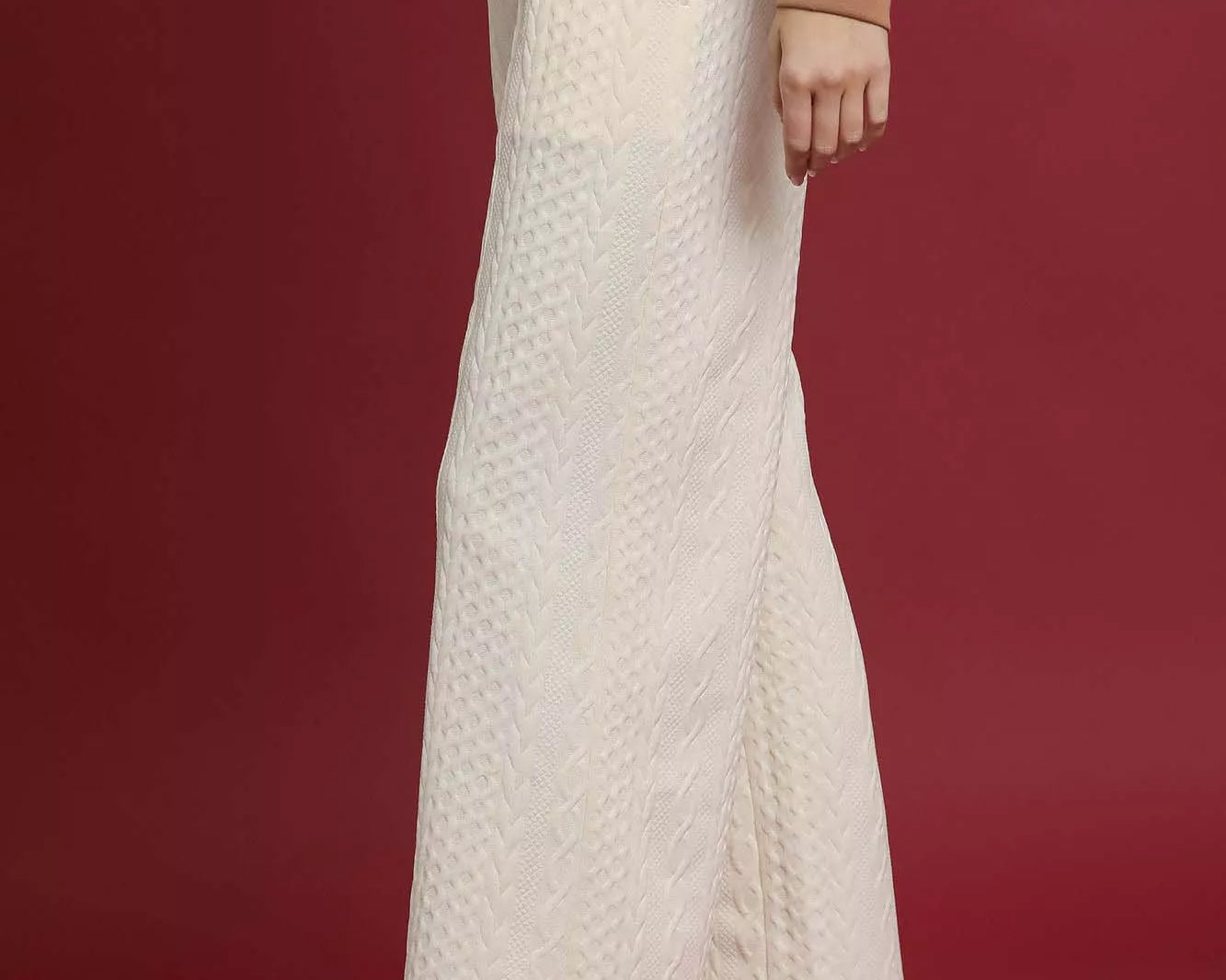 NEWYORKLISTED STYLE COLLECTION: Person wearing a textured white skirt with a brown top and shoes on a red background