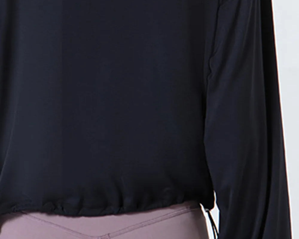 NEWYORKLISTED ACTIVEWEAR COLLECTION: Black long-sleeve top worn by a person on a white background
