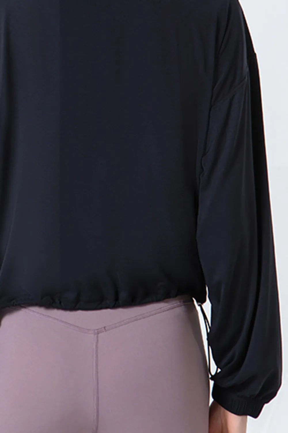 NEWYORKLISTED ACTIVEWEAR COLLECTION: Black long-sleeve top worn by a person on a white background