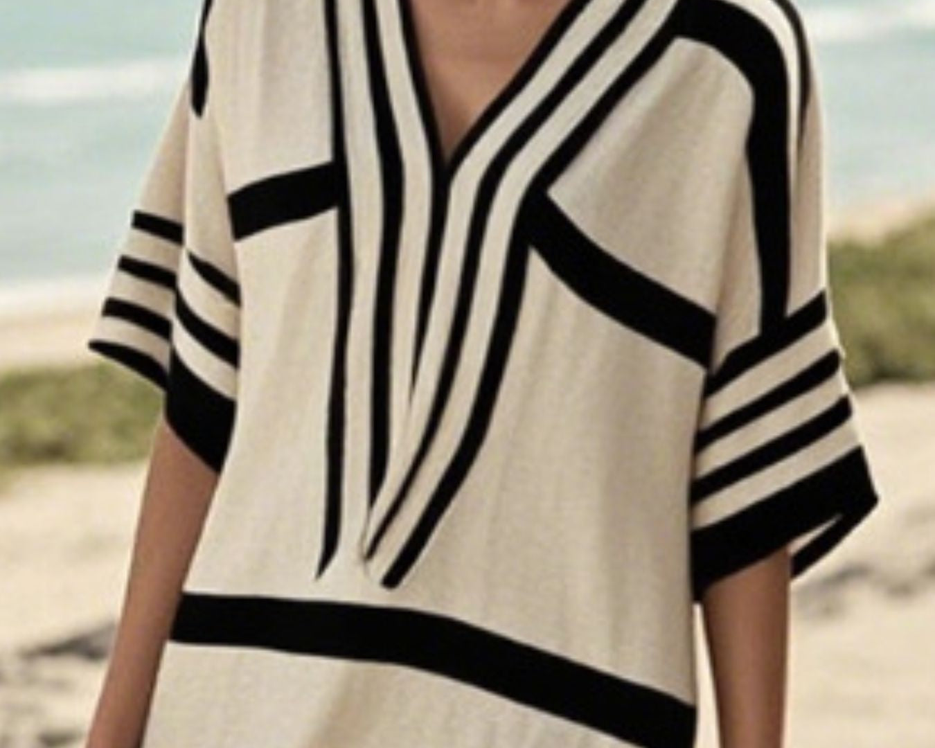 NEWYORKLISTED STYLE COLLECTION: Woman wearing a black and white striped dress on a beach
