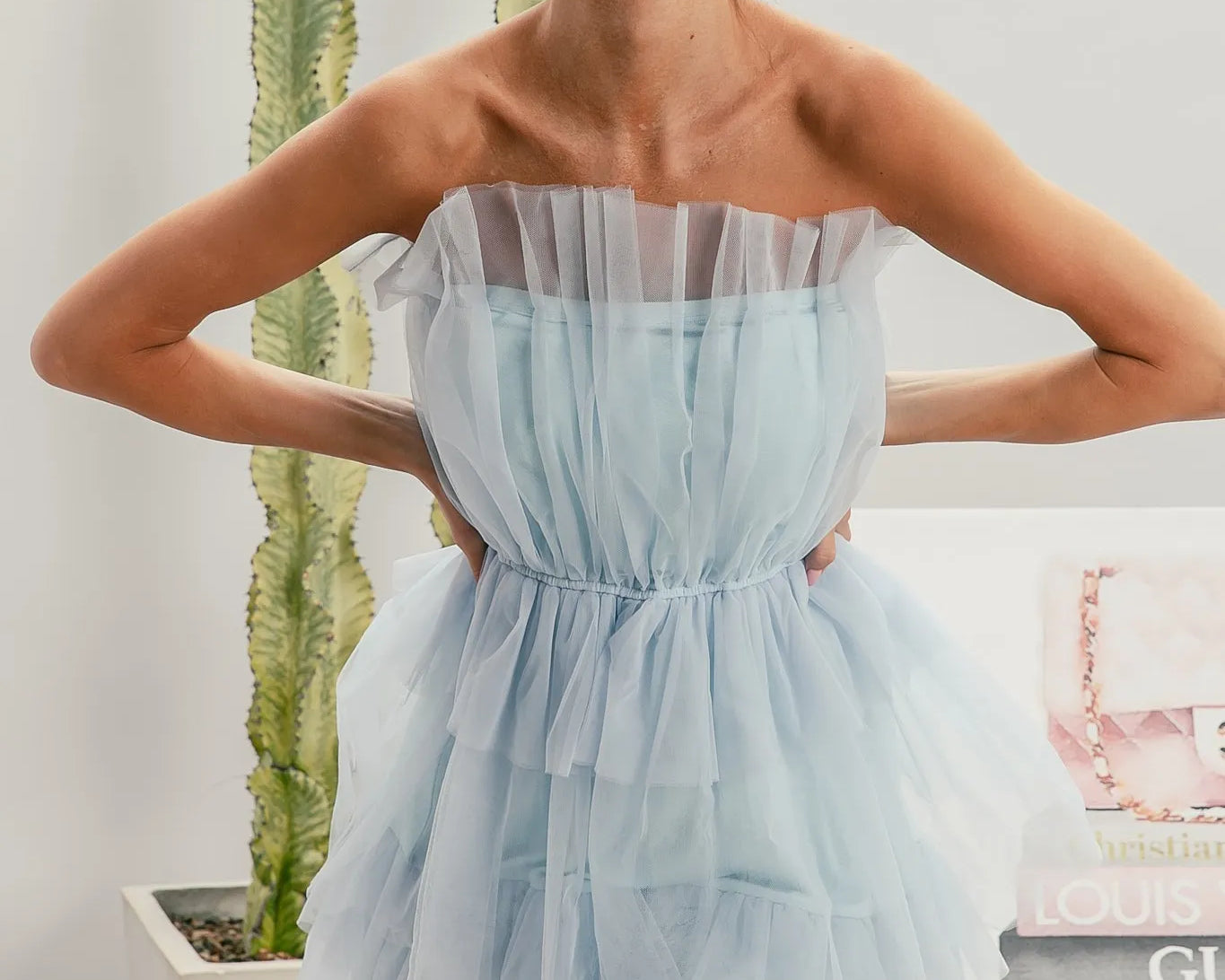 NEWYORKLISTED STYLE COLLECTION: Sleeveless Layered Organza Dress Woman wearing a light blue strapless dress with sunglasses indoors.