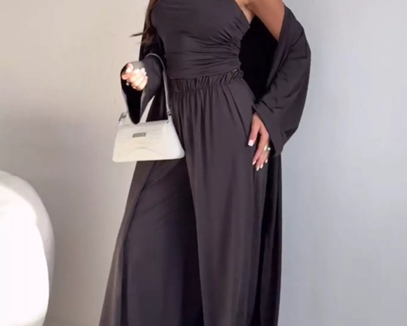 NEWYORKLISTED COMFORT COLLECTION: Woman wearing a dark gray off-shoulder dress with long sleeves against a plain background