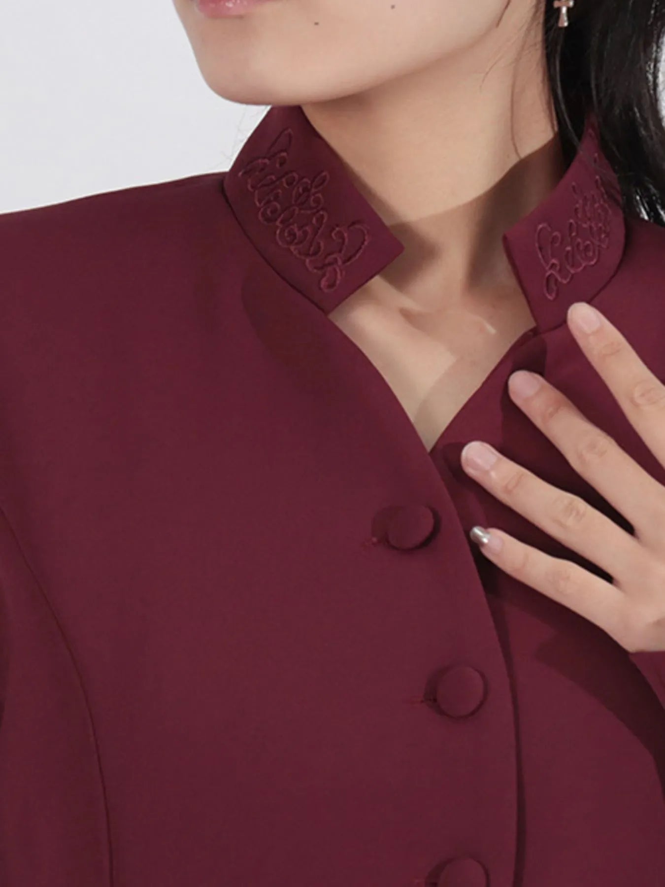 NEWYORKLISTED STYLE COLLECTION: Close-up of a burgundy coat with intricate detailing on the collar.