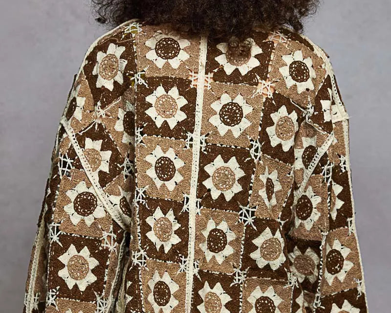 Person wearing a patterned jacket with a gray background