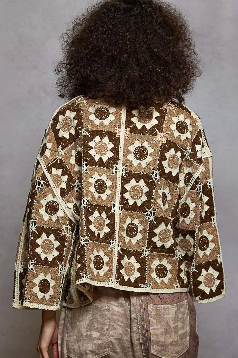 Person wearing a patterned jacket with a gray background