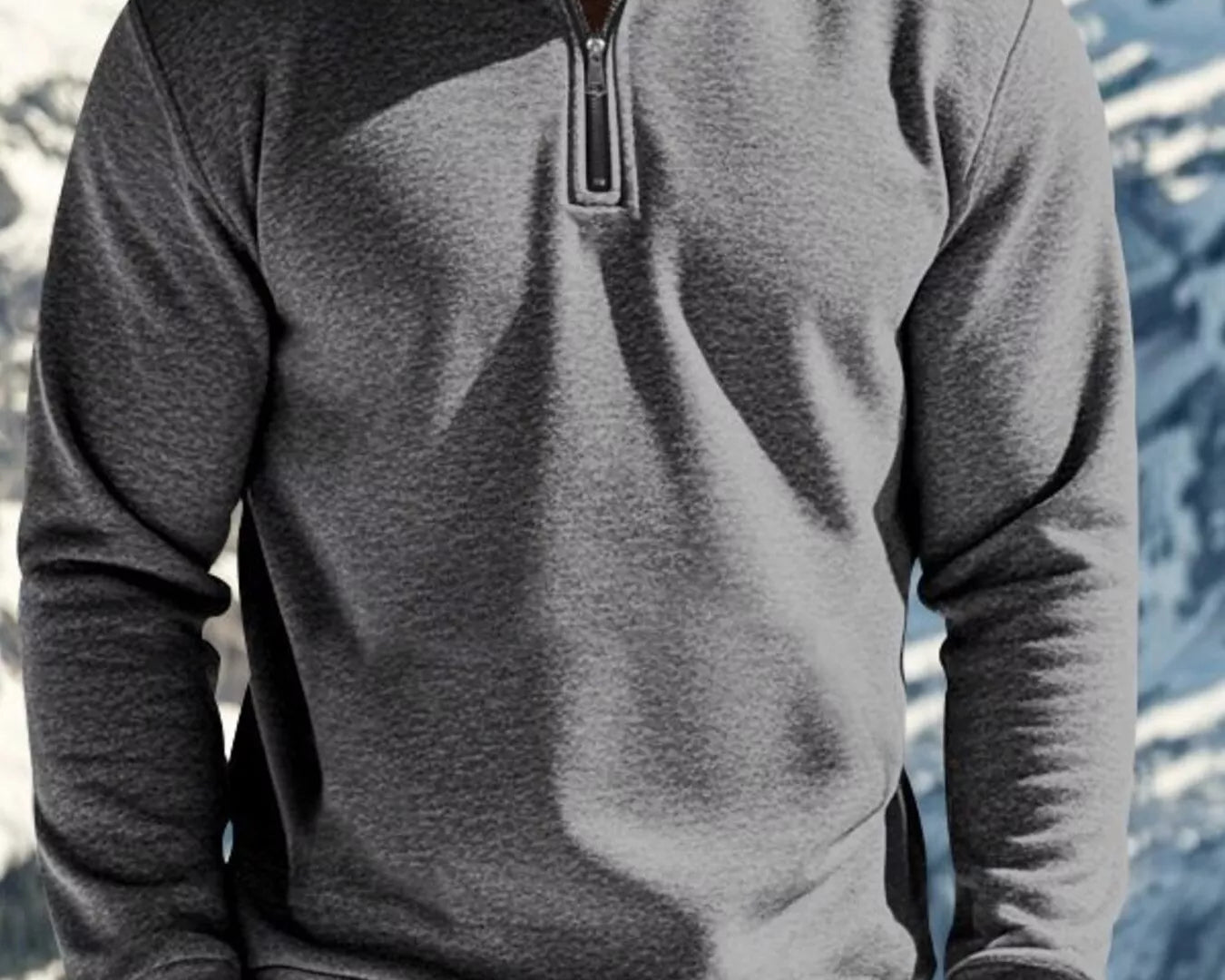 NEWYORKLISTED ATLAS MEN'S COLLECTION: Person wearing a gray half-zip pullover with a mountainous background