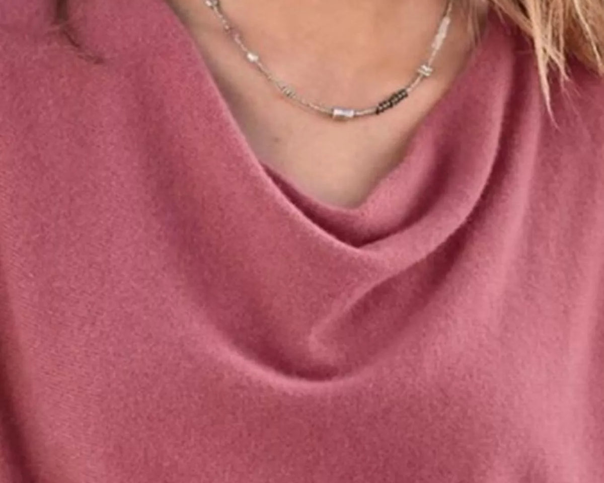 NEWYORKLISTED STYLE COLLECTION: Close-up of a person wearing a pink garment and a necklace with a blurred background