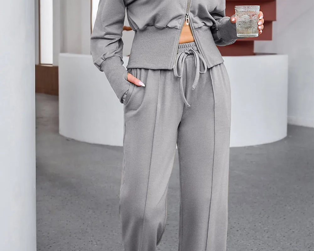 NEWYORKLISTED ACTIVEWEAR COLLECTION: Woman wearing a gray tracksuit in an indoor setting