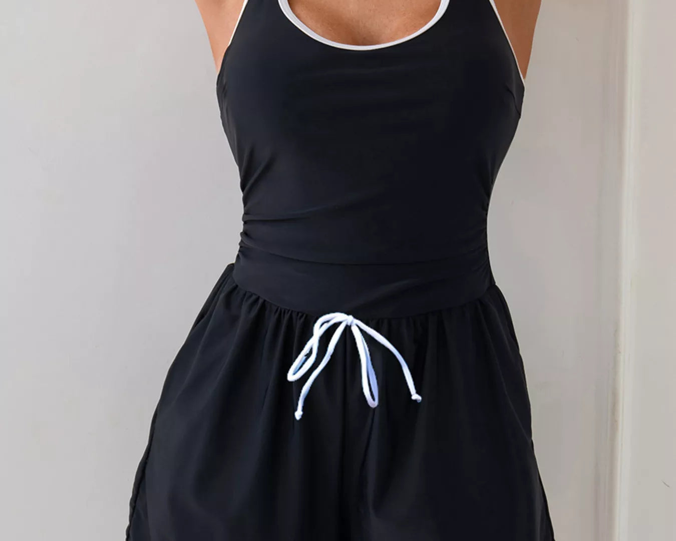 NEWYORKLISTED STYLE COLLECTION: Black tank top and shorts set with white trim on a plain background