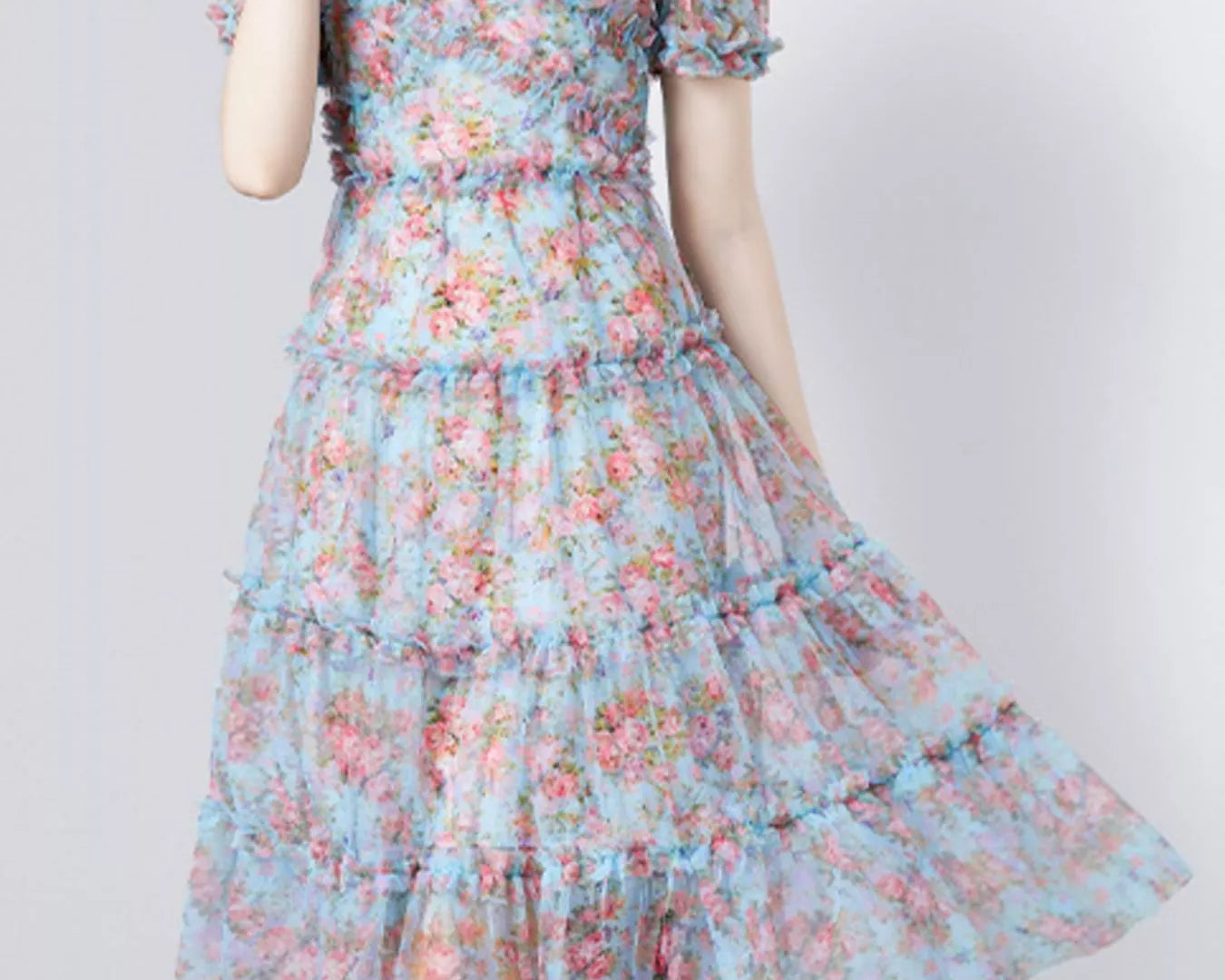 NEWYORKLISTED STYLE COLLECTION: Woman wearing a floral dress on a plain background