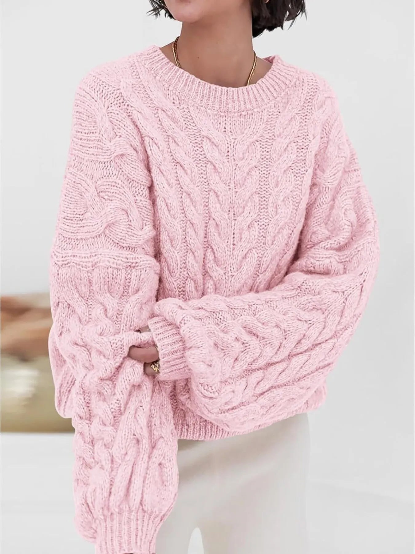 NEWYORKLISTED STYLE COLLECTION: Person wearing a pink cable knit sweater against a light background
