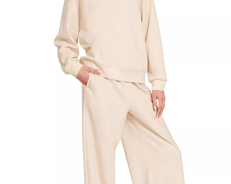 NEWYORKLISTED STYLE COLLECTION: Woman wearing a beige outfit with wide-leg pants on a white background