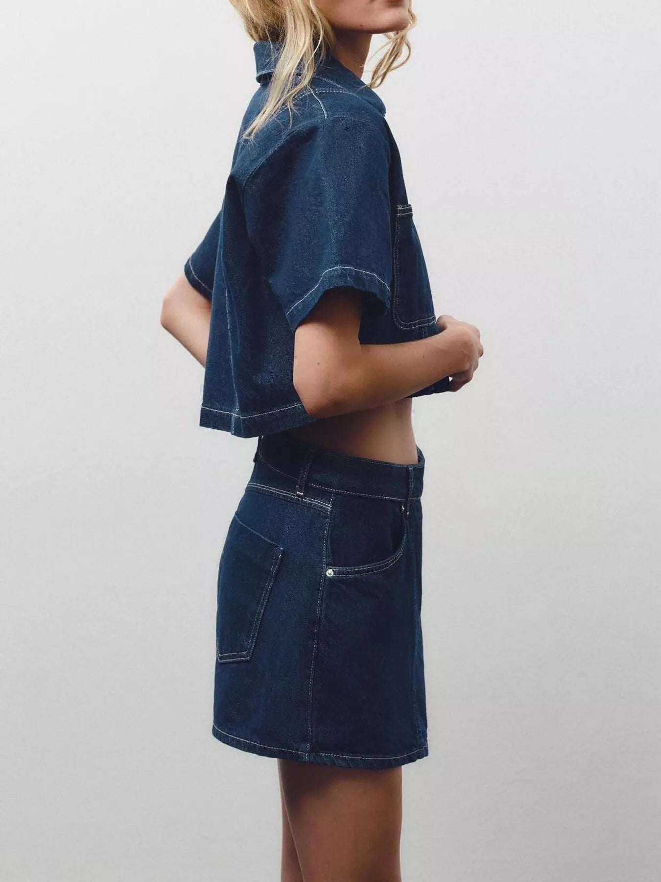 NEWYORKLISTED STYLE COLLECTION: Person wearing a dark blue denim outfit on a plain background