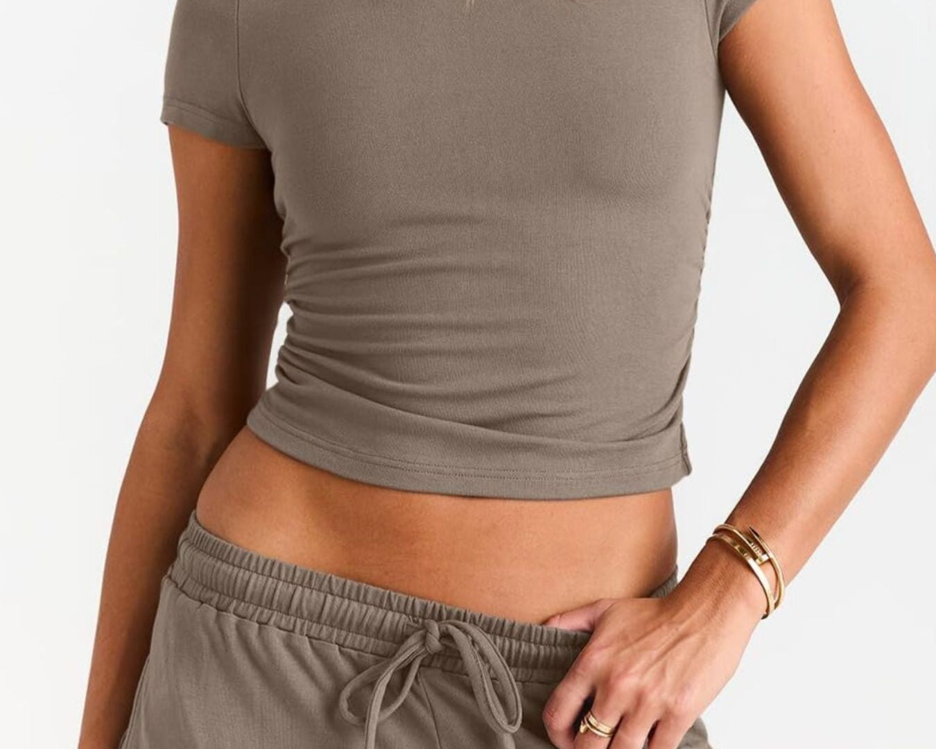 NEWYORKLISTED COMFORT COLLECTION: Person wearing a brown crop top and pants on a white background
