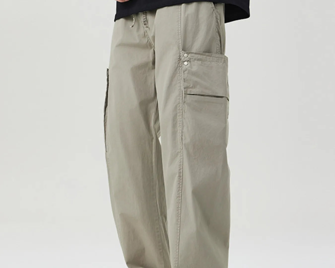 NEWYORKLISTED ATLAS MEN's COLLECTION: Person wearing beige cargo pants and a black t-shirt on a white background