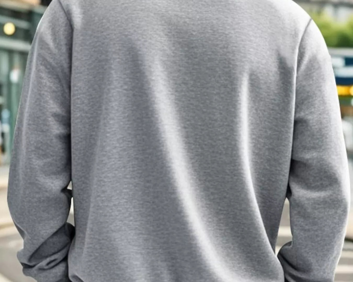NEWYORKLISTED ATLAS MEN'S COLLECTION: Person wearing a gray sweatshirt with a blurred urban background