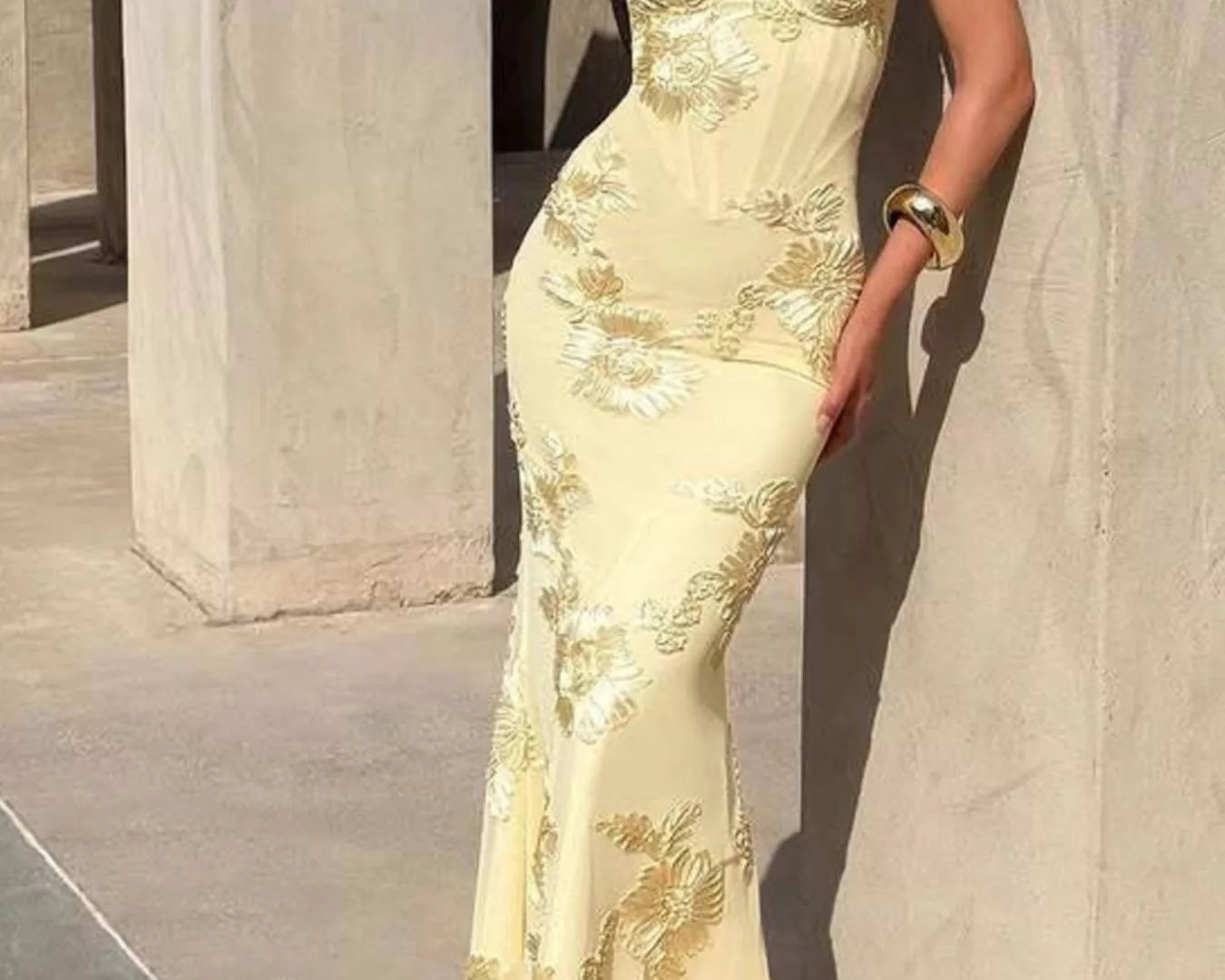 NEWYORKLISTED STYLE COLLECTION: Woman wearing a yellow lace evening gown against a neutral background