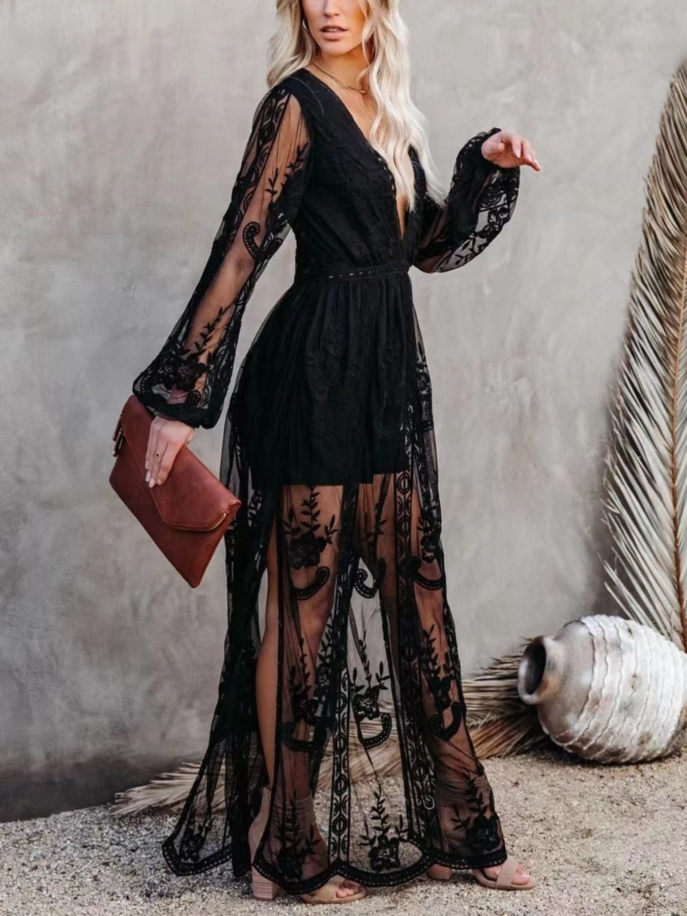 NEWYORKLISTED STYLE COLLECTION: Woman wearing a black lace dress holding a brown clutch against a neutral background
