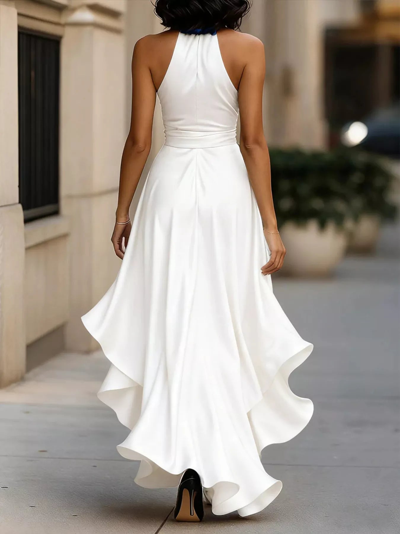 NEWYORKLISTED STYLE COLLECTION: Woman wearing a white halter neck dress walking on a sidewalk.