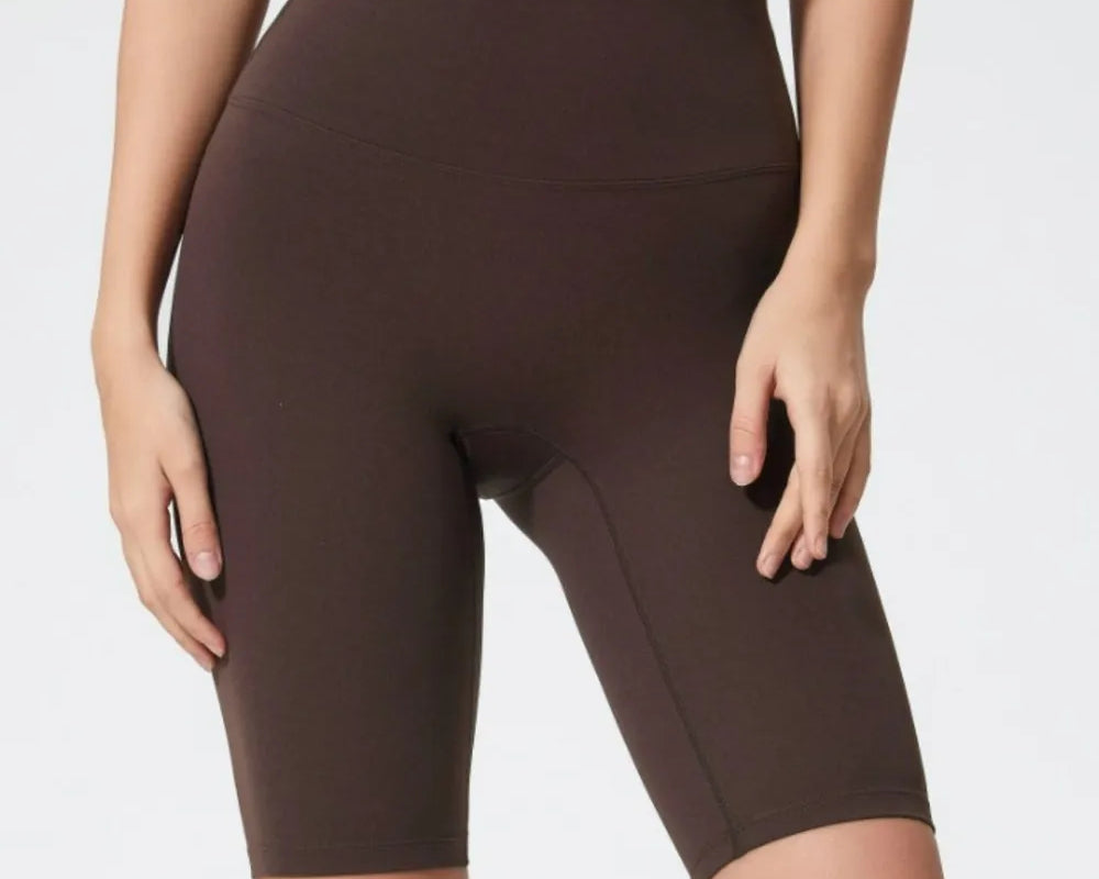 NEWYORKLISTED ACTIVEWEAR COLLECTION: Brown athletic shorts worn by a person on a white background