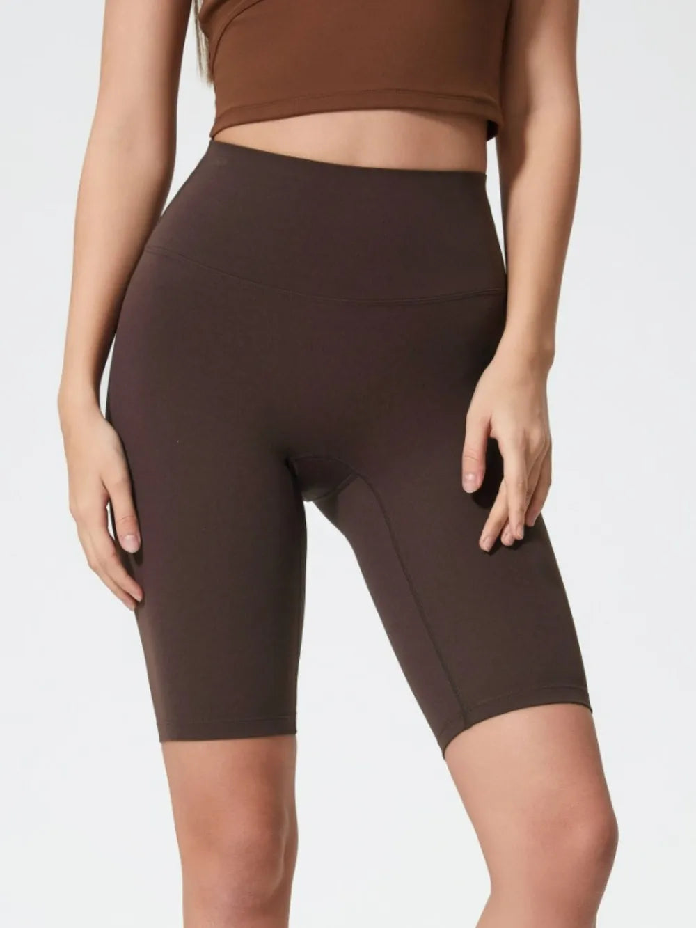 NEWYORKLISTED ACTIVEWEAR COLLECTION: Brown athletic shorts worn by a person on a white background