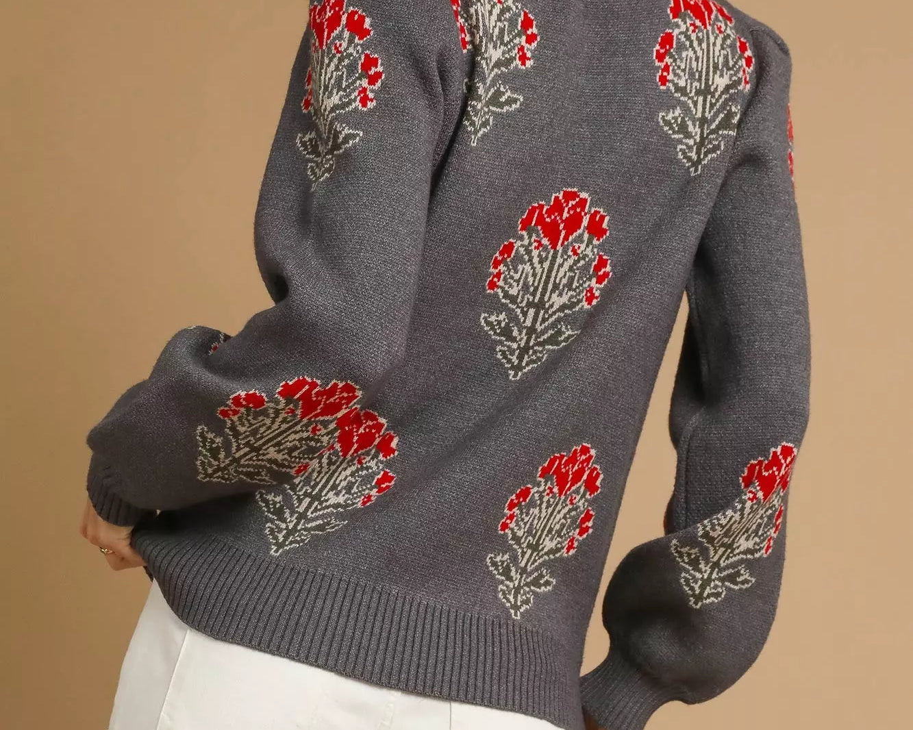 NEWYORKLISTED STYLE COLLECTION: Gray sweater with red floral patterns worn by a person on a beige background