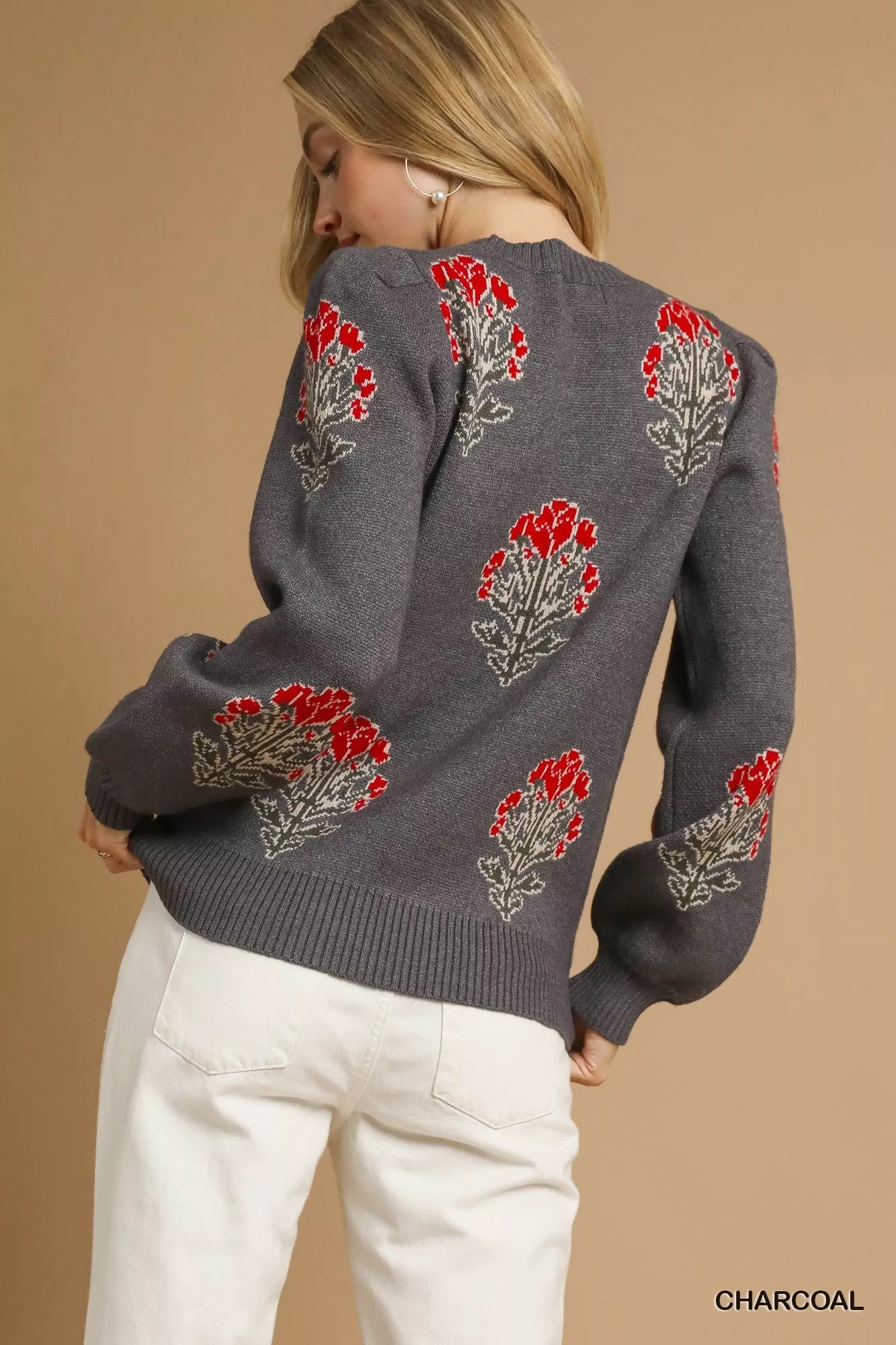 NEWYORKLISTED STYLE COLLECTION: Gray sweater with red floral patterns worn by a person on a beige background