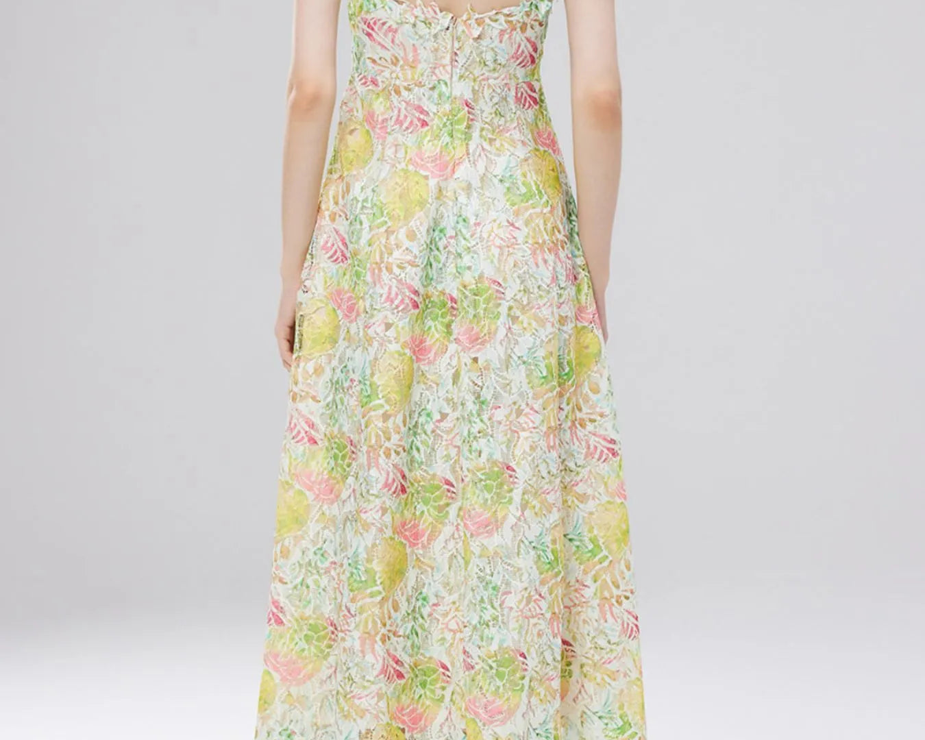 NEWYORKLISTED STYLE COLLECTION: Woman wearing a floral dress on a plain background
