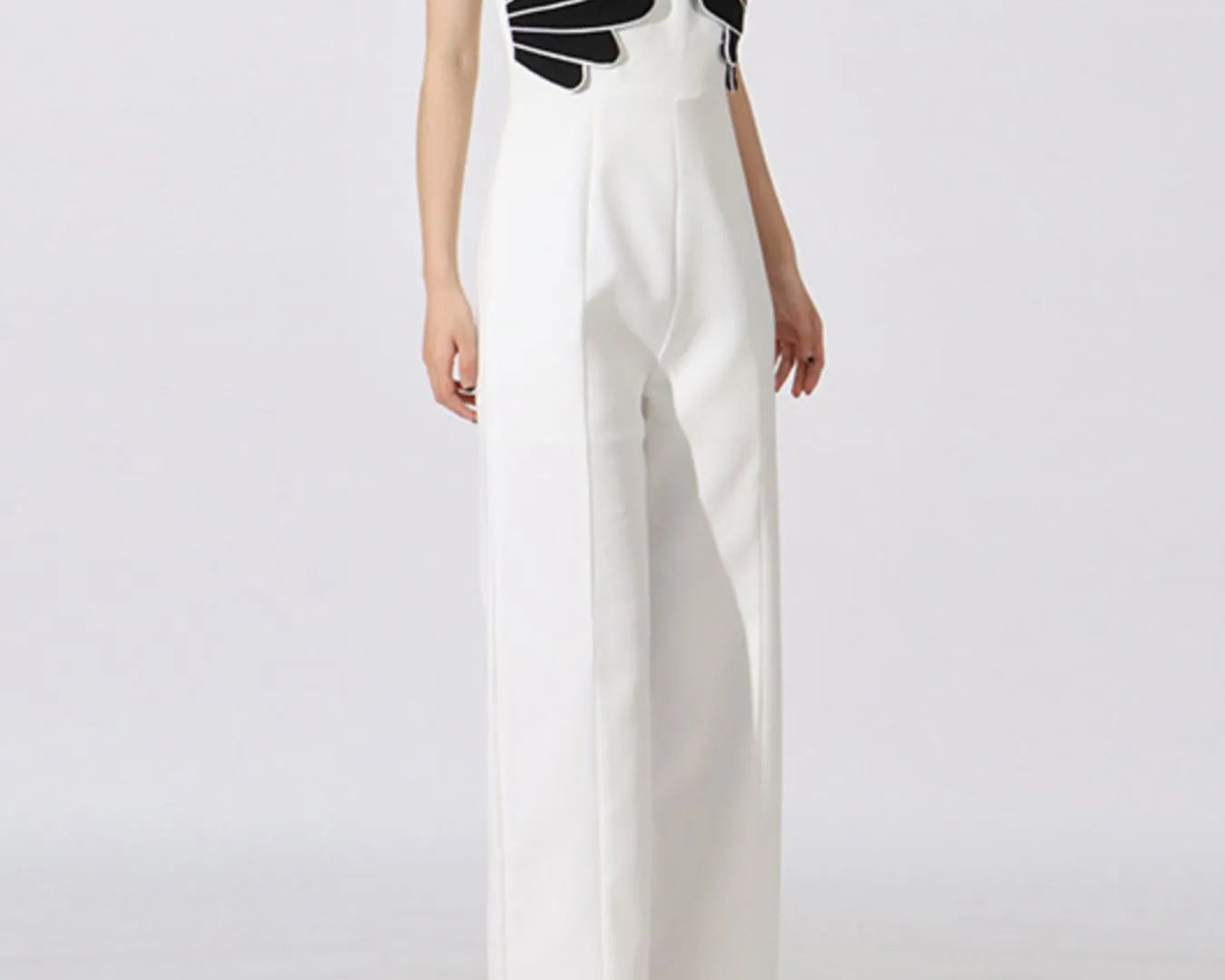 NEWYORKLISTED: White jumpsuit with black geometric top on a white background