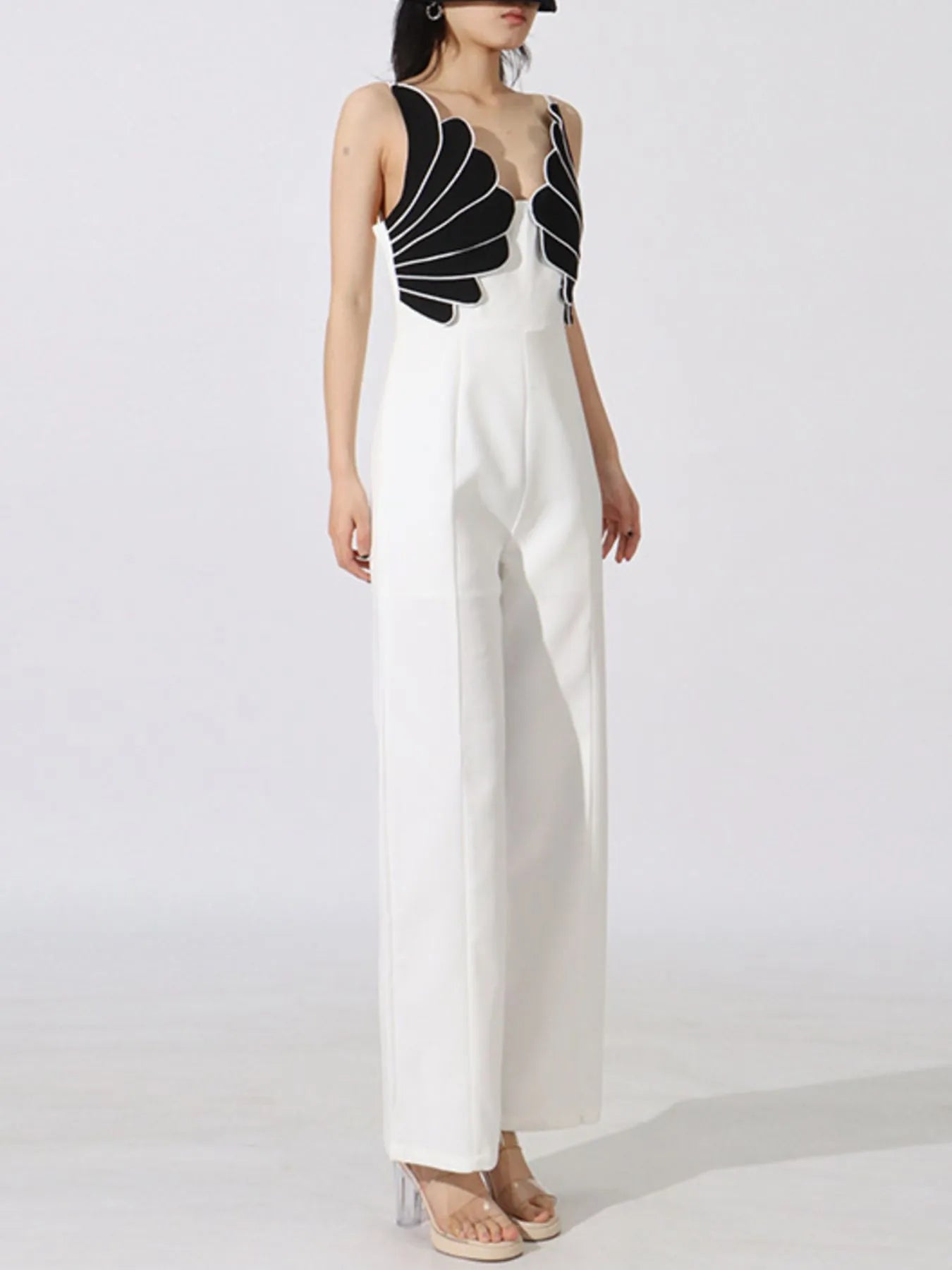 NEWYORKLISTED: White jumpsuit with black geometric top on a white background