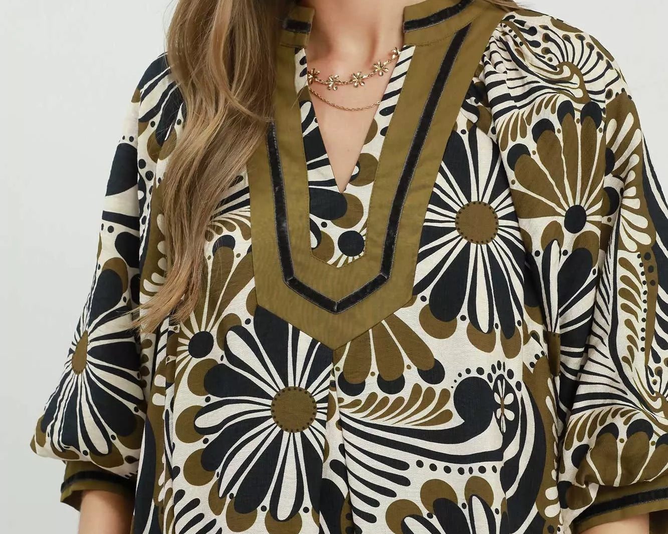 NEWYORKLISTED STYLE COLLECTION: Woman wearing a patterned dress with a neutral background