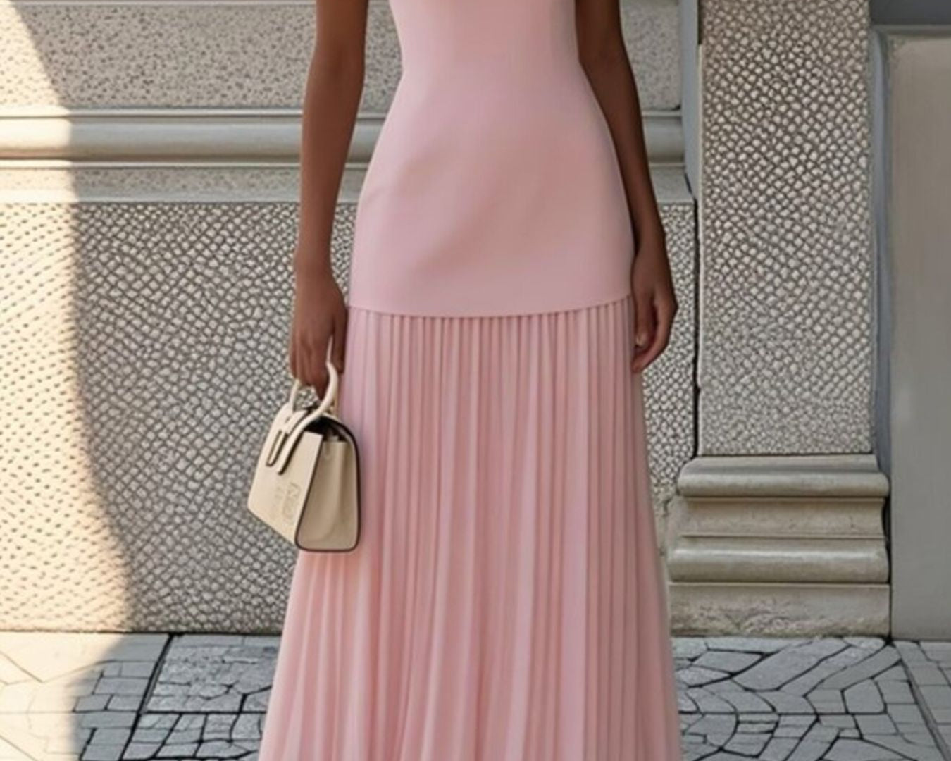NEWYORKLISTED STYLE COLLECTION: Woman wearing a pink dress standing on a stone pavement with a textured wall background