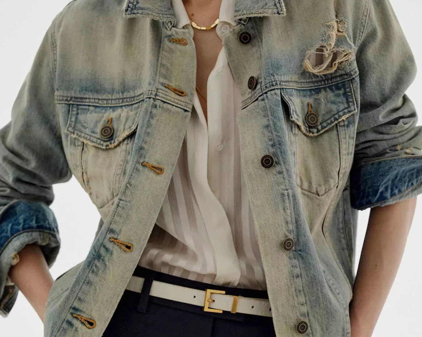 NEWYORKLISTED STYLE COLLECTION: Person wearing a light blue denim jacket over a white shirt with a plain background