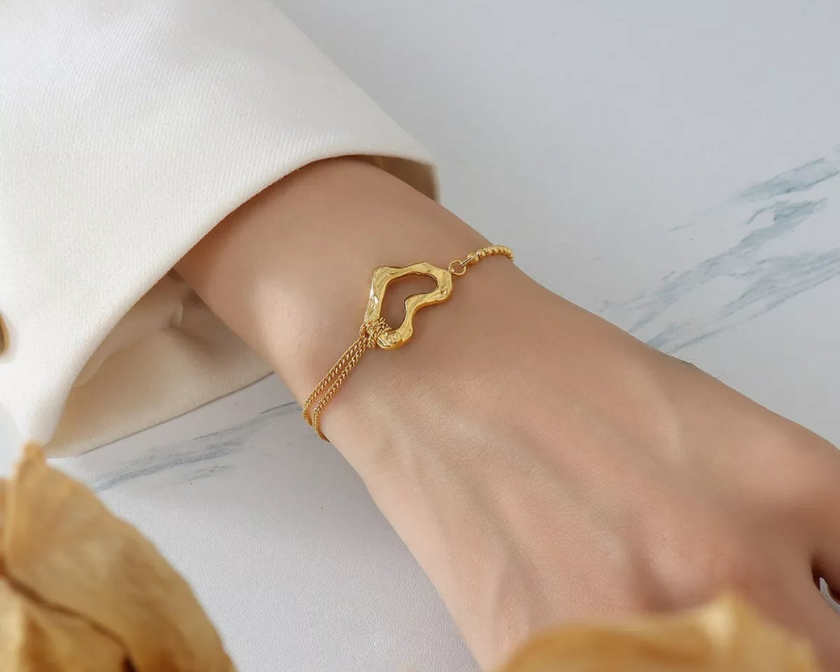 NYLD Glamour Collection by NEWYORKLISTED: Gold bracelet on a wrist with a blurred background