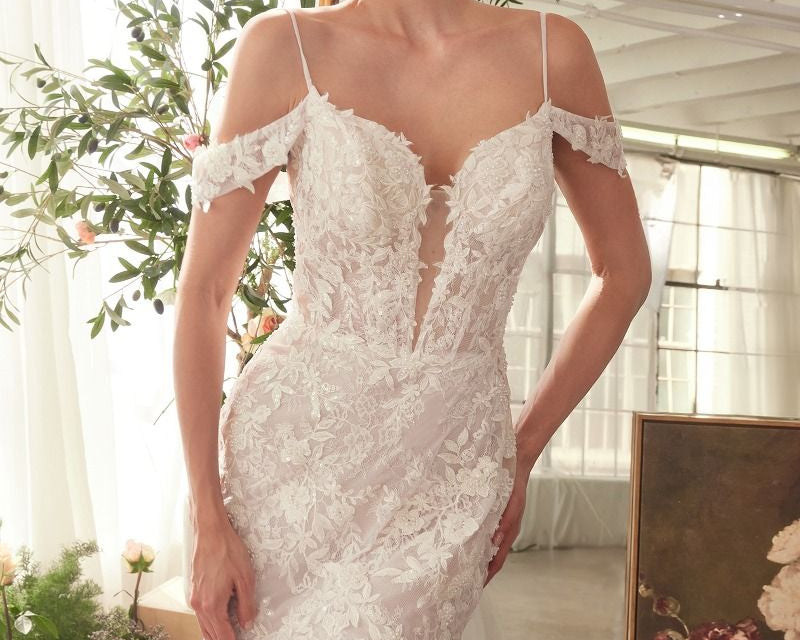 NEWYORKLISTED ELEGANT BRIDE COLLECTION: Woman wearing a white lace wedding dress in a decorated room with flowers and mirrors.