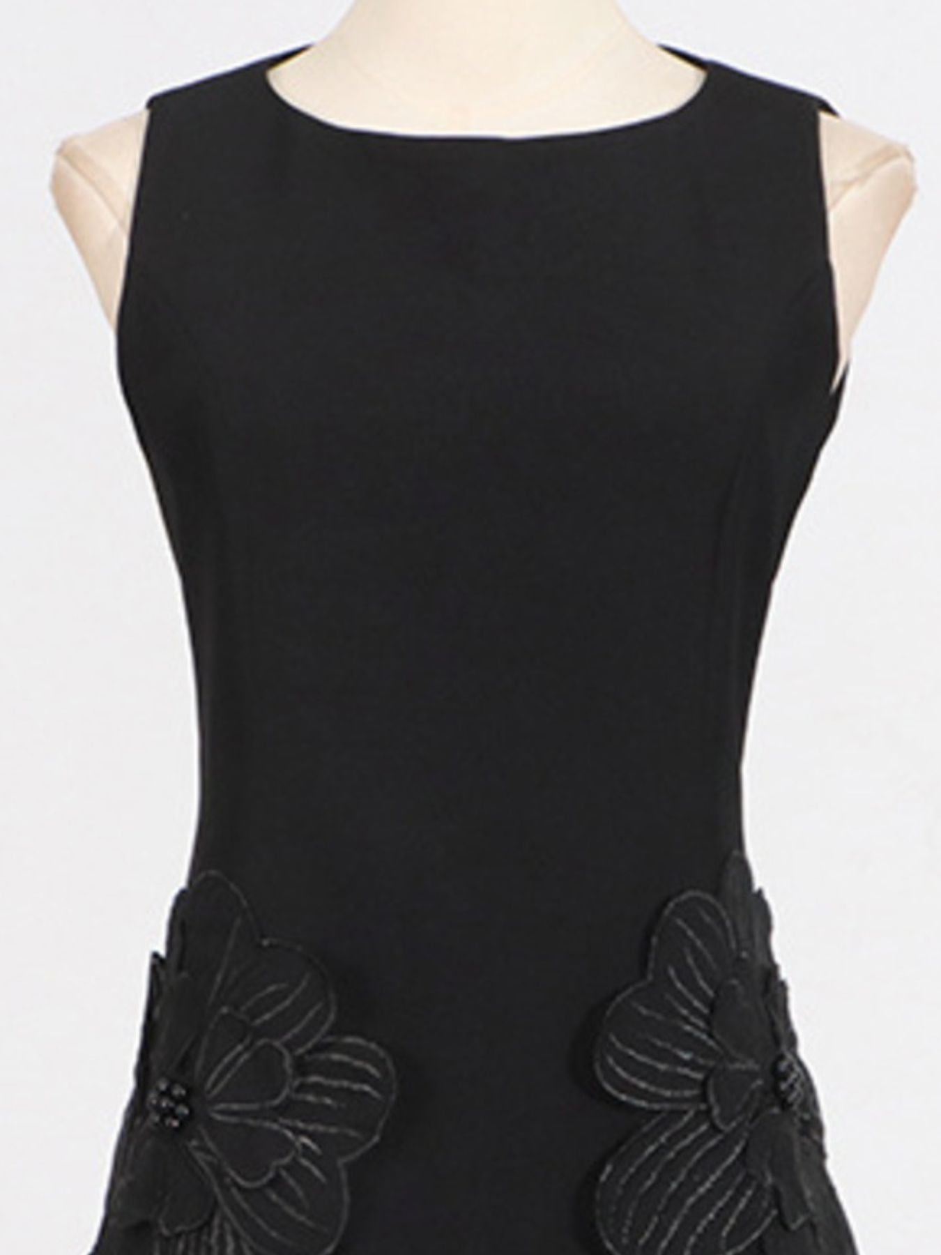 NEWYORKLISTED STYLE COLLECTION: Black sleeveless dress with floral appliqués on a mannequin against a white background