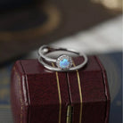 NYLD Glamour Collection by NEWYORKLISTED: Silver ring with a blue gemstone on a wooden box