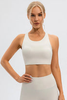 NEWYORKLISTED ACTIVEWEAR COLLECTION: Woman wearing a white sports bra and leggings on a light gray background