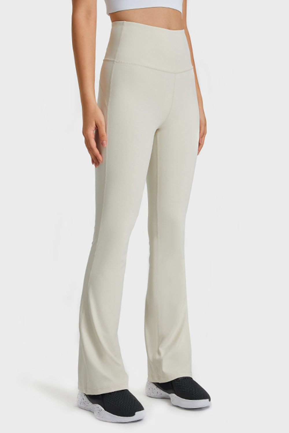 NEWYORKLISTED ACTIVEWEAR COLLECTION: Person wearing beige high-waisted pants on a white background