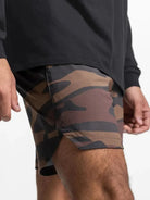 NEWYORKLISTED ATLAS MEN'S COLLECTION: Person wearing camouflage shorts and a black long-sleeve shirt on a white background