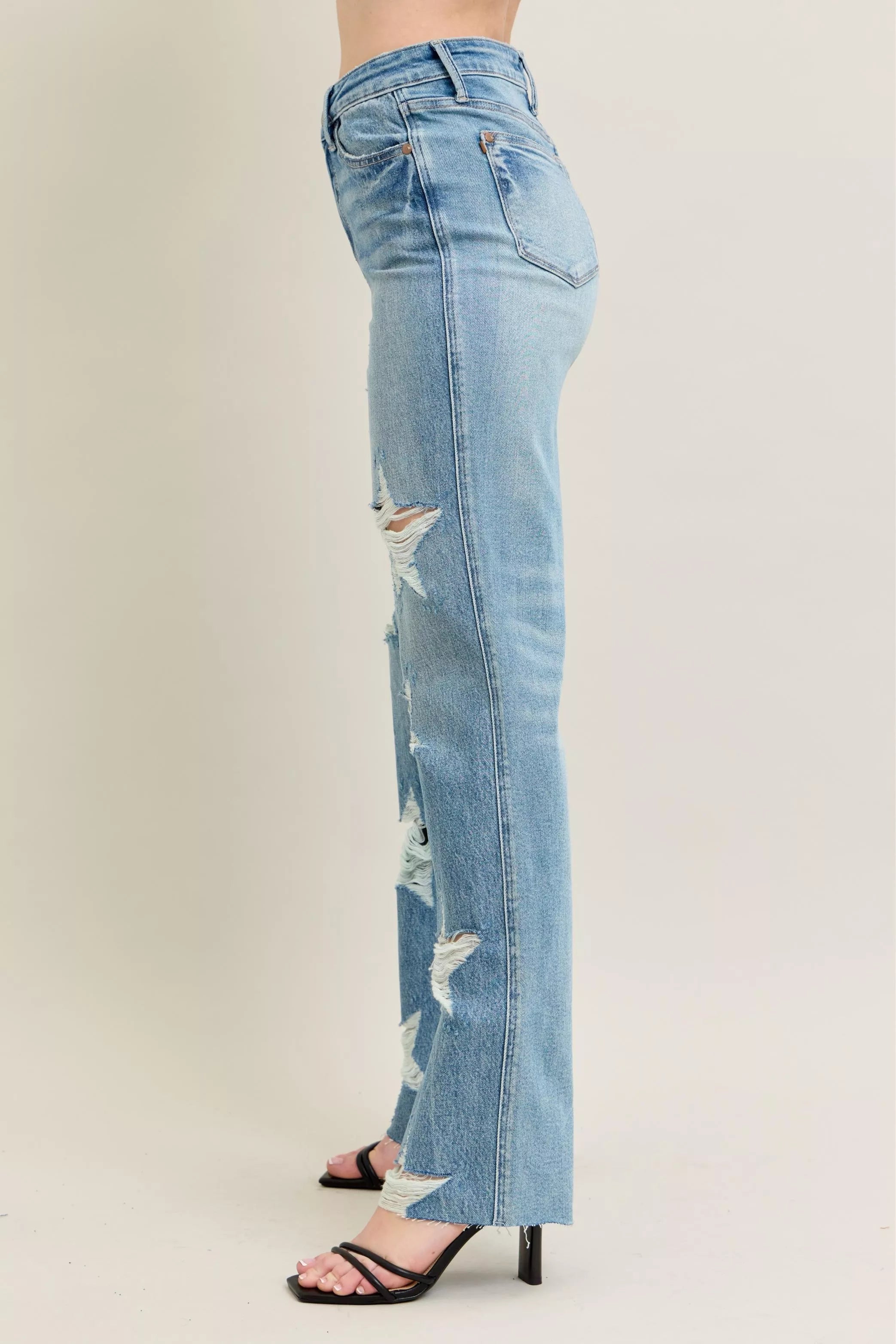 NEWYORKLISTED STYLE COLLECTION: Light blue distressed jeans worn by a person on a plain background