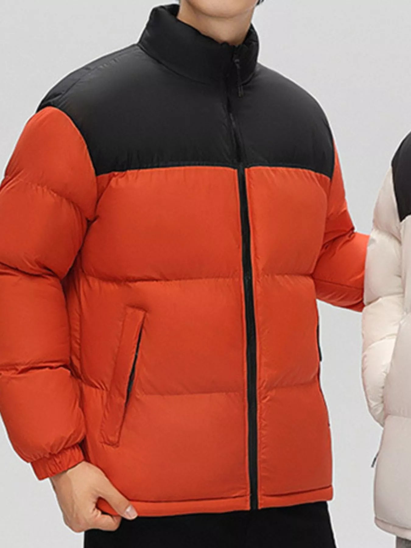 NEWYORKLISTED ATLAS MEN’S COLLECTION: Orange red and black puffer jacket worn by a person on a plain background