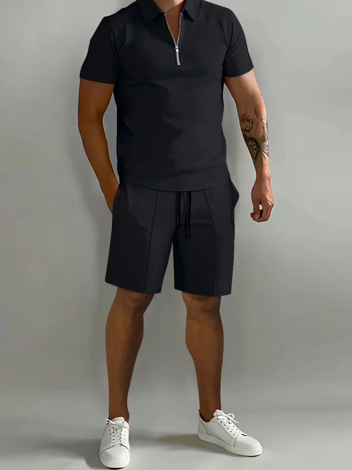 NEWYORKLISTED ATLAS MEN's COLLECTION: Male model wearing a black polo shirt and shorts with white sneakers on a gray background