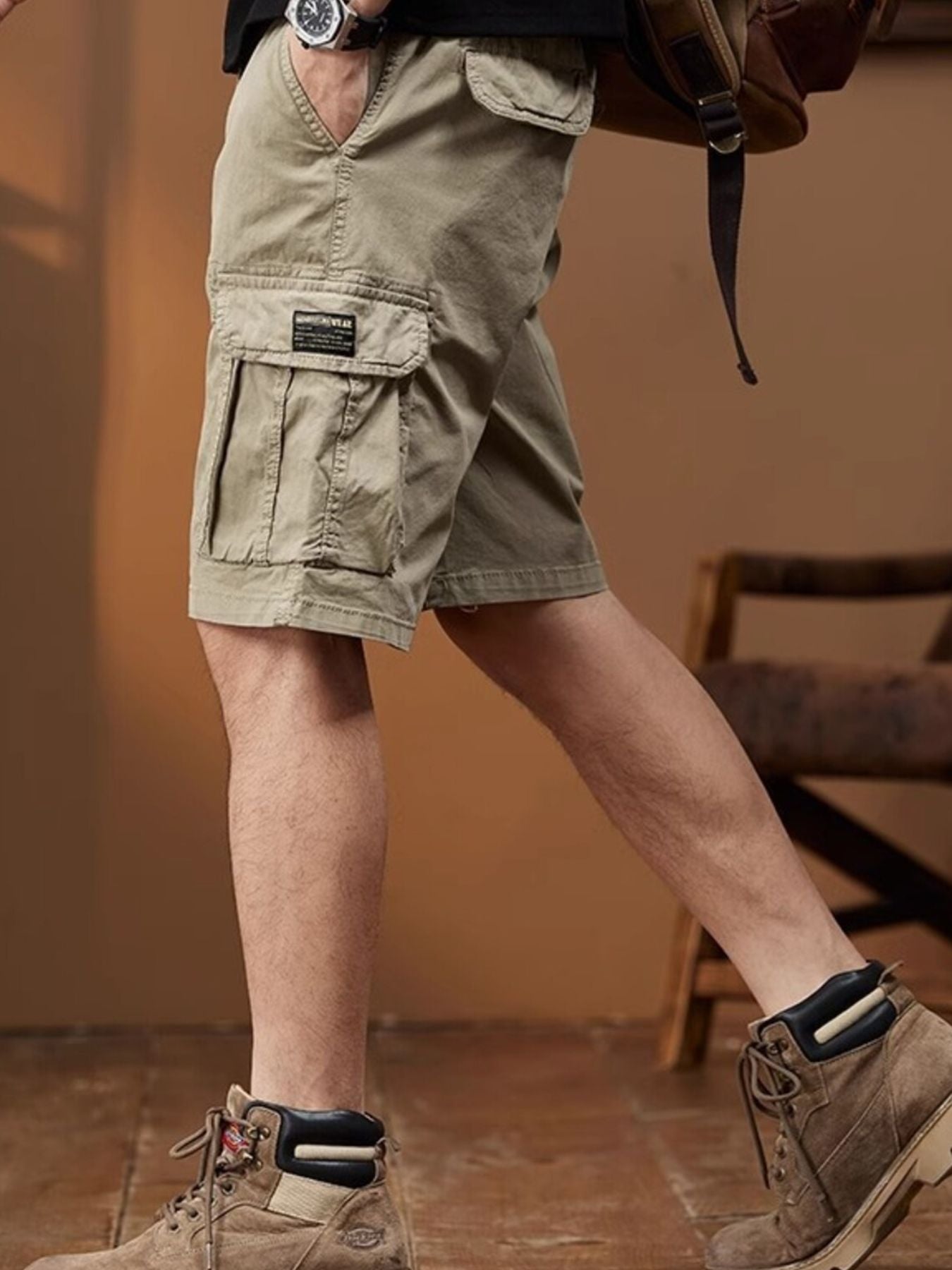 NEWYORKLISTED ATLAS MEN's COLLECTION: Person wearing khaki cargo shorts and brown boots indoors.