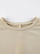 NEWYORKLISTED STYLE COLLECTION: Close-up of a beige t-shirt collar on a white background